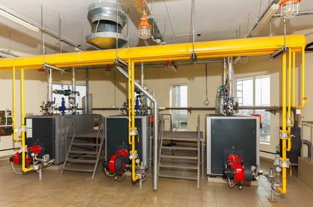 内政部工业燃气锅炉房用许多管道和煮设备, 工业工具和在工厂车间里的